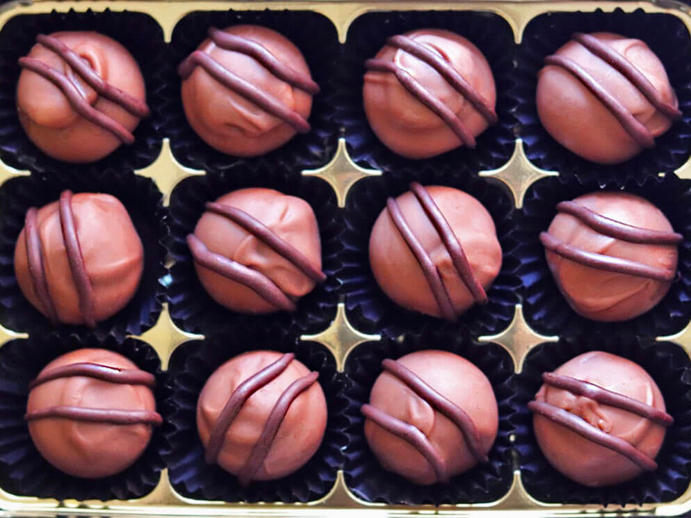 Image shows a box of 12 hand made Intense Orange Chocolate Truffles. Great Taste Award winners.