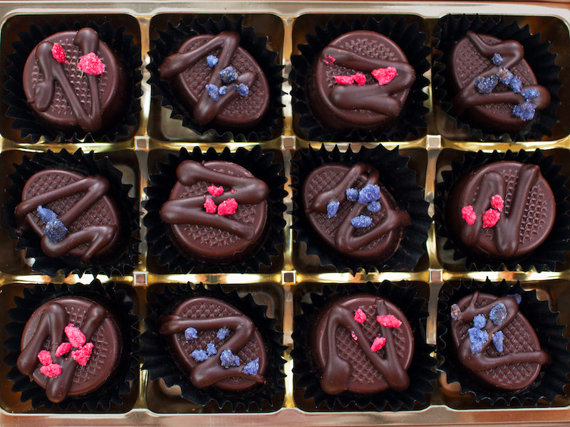 image shows a collection of 12 chocolates containing 6 each of rose creams and violet creams