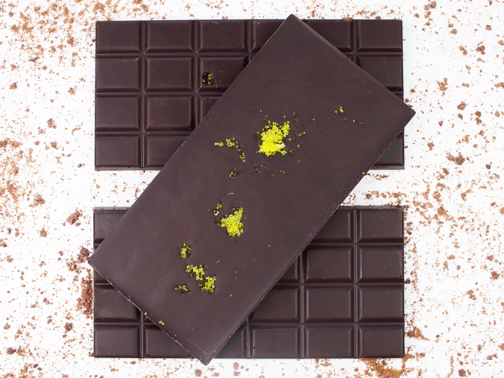 image shows 3, 100g vegan dark chocolate lemon bars, one with lemon sugar sprinkle on the back.