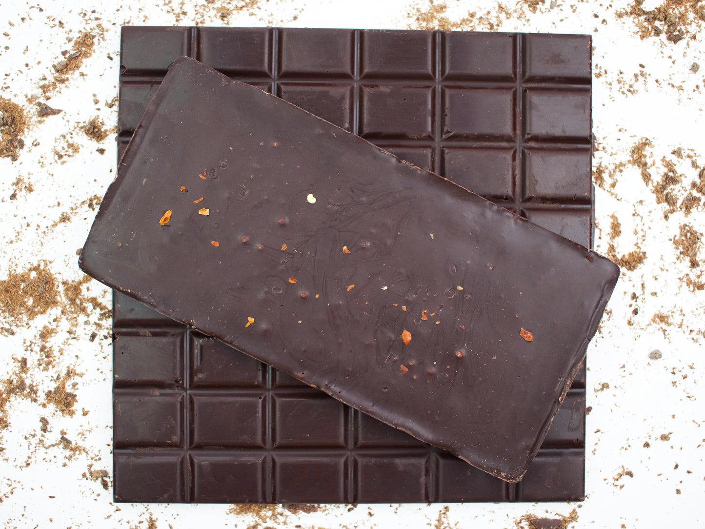 image shows 3, 100g hand made dark chocolate chilli bars, 2 viewed from the top and 1 viewed from the underside showing chilli flakes
