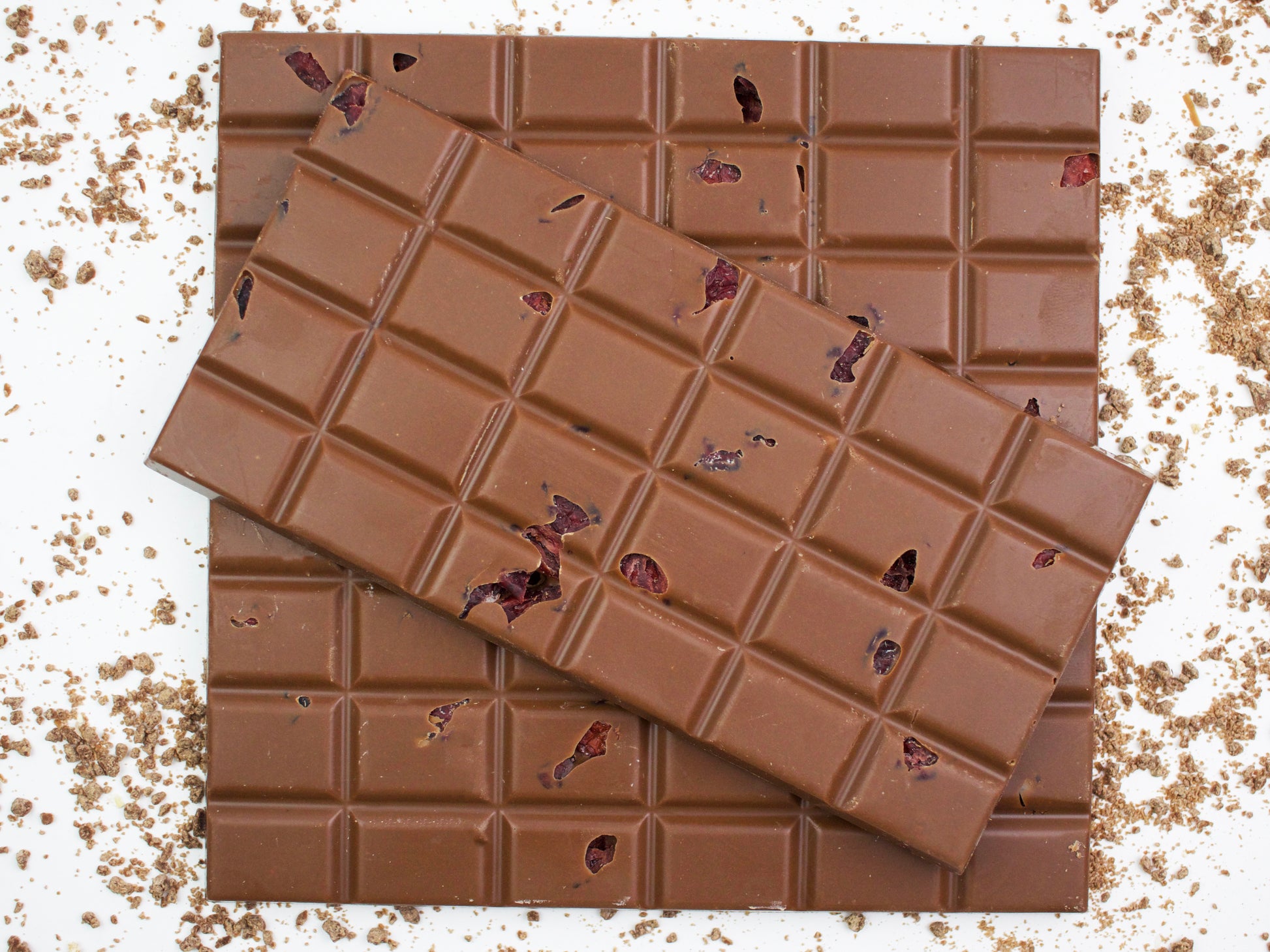 image shows 3, hand made milk chocolate bars embedded with cranberries and flavoured with orange.