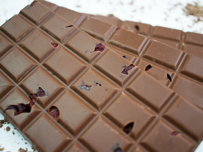 image shows a close up of 3 milk chocolate cranberry and orange hand made chocolate bars.