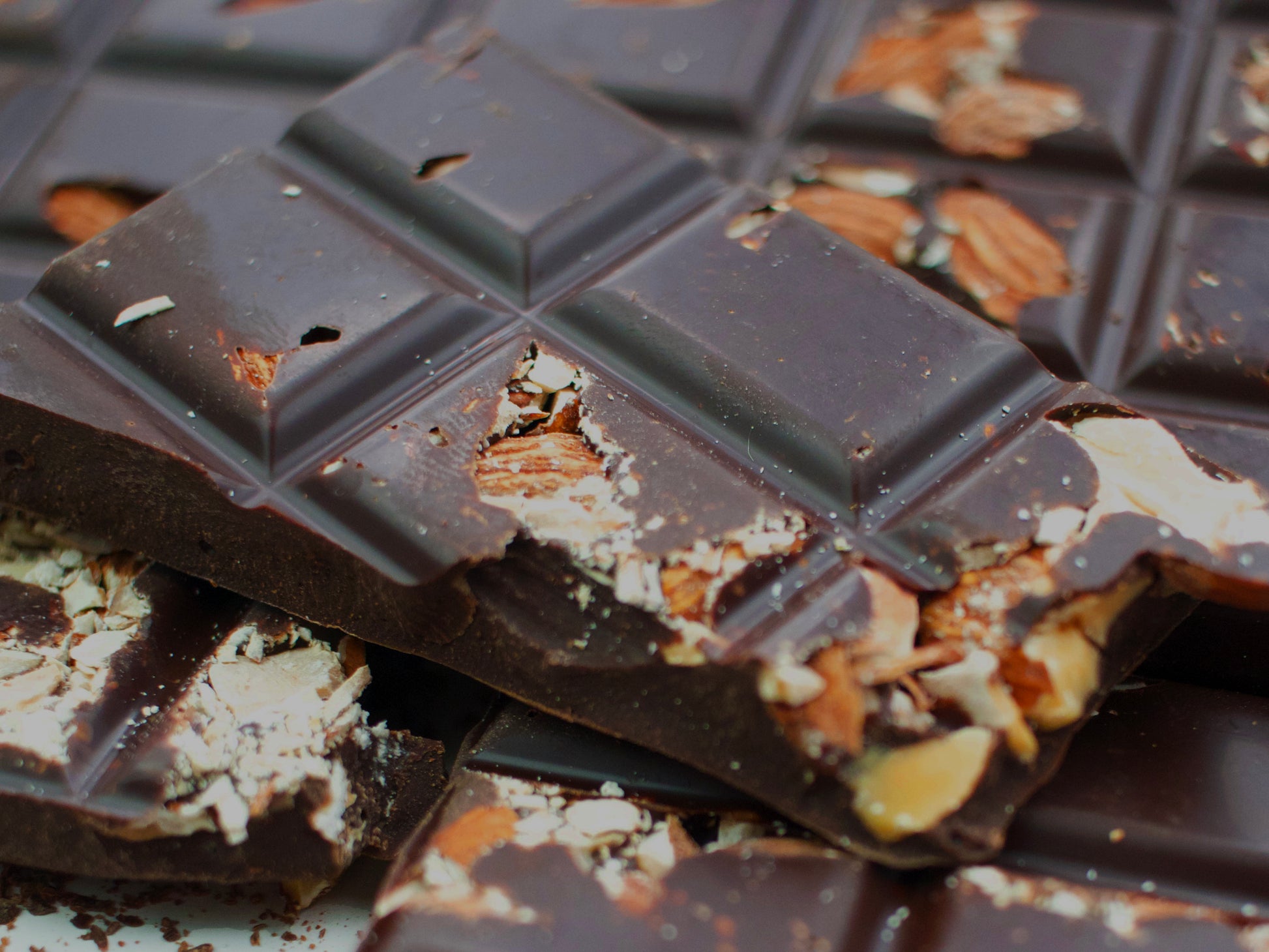 image shows close up of sugar free dark almond bar with embedded almonds.
