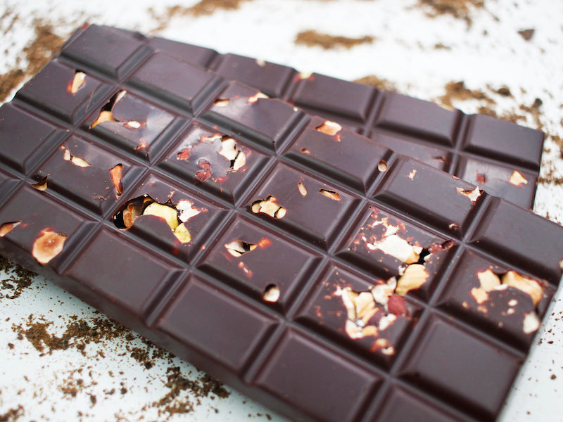 image shows a close up of hand made dark sugar free chocolate 100g bar embedded with hazelnuts.