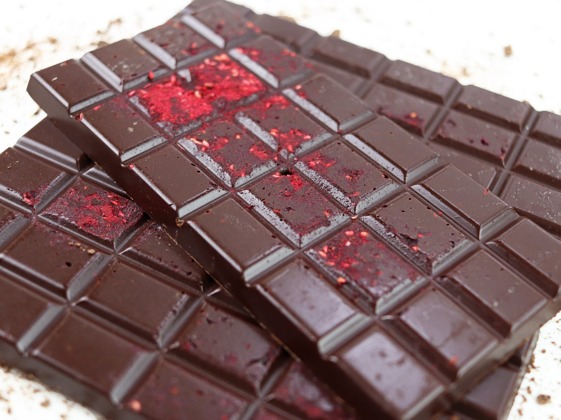 image shows 3, 100g hand made dark chocolate raspberry bars embedded with raspberry pieces.
