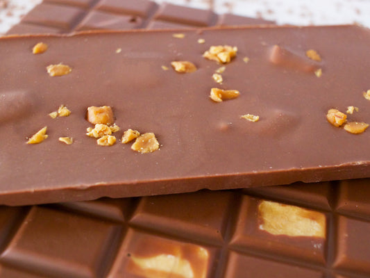 image shows a close up of a 100g hand made milk chocolate bar, embedded with pieces of our own recipe vanilla fudge.