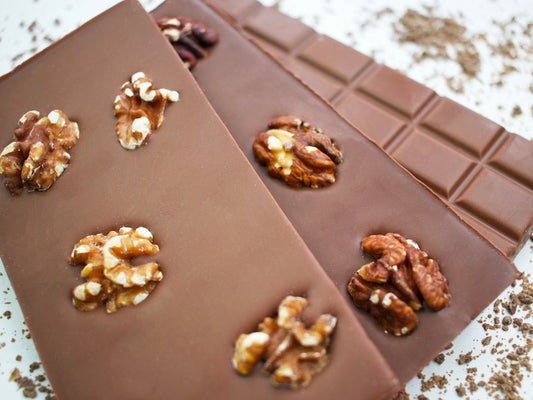 image shows a close up of the back and front views of 100g hand made milk chocolate orange and walnut bars.