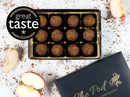 Image shows a gift box of dairy cream apple truffles with pieces of apple and the Great Taste award logo.