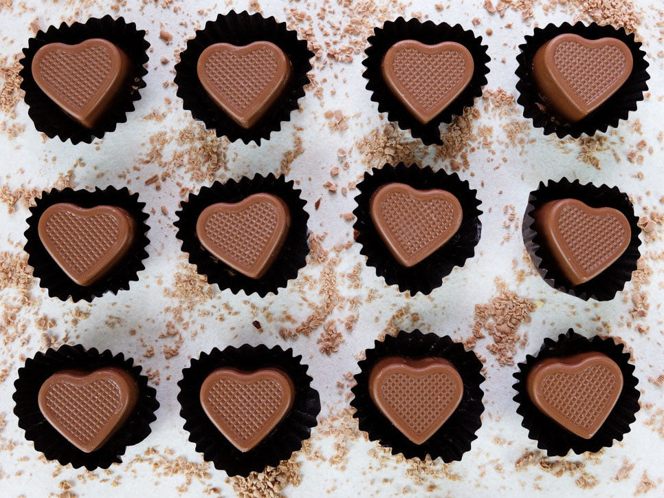Image shows 12 heart shaped milk chocolates that are filled with caramel