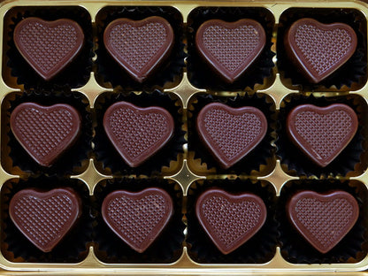 Image shows a gift box of 12 hand crafted dark chocolate hearts that are filled with caramel.