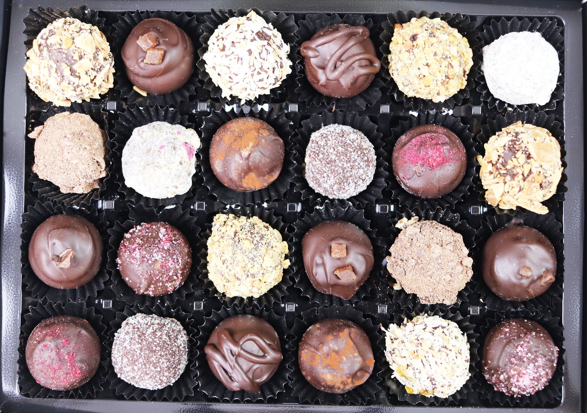 image shows a selection box of 24 vegan hand made dark chocolate truffles