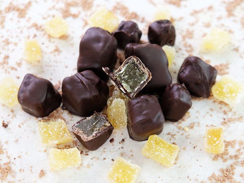 Image shows chunks of dark chocolate covered crystallised stem ginger.