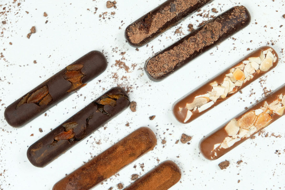 images shows pack contents, 2 each of apricot, dark chocolate, almond and cinnamon, sugar free batons, chunky chocolate fingers.
