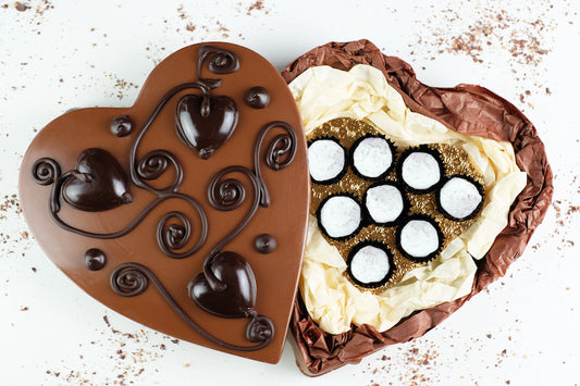 image shows a hand made vegan milk chocolate heart shaped box containing 8 vegan peanut butter chocolates.